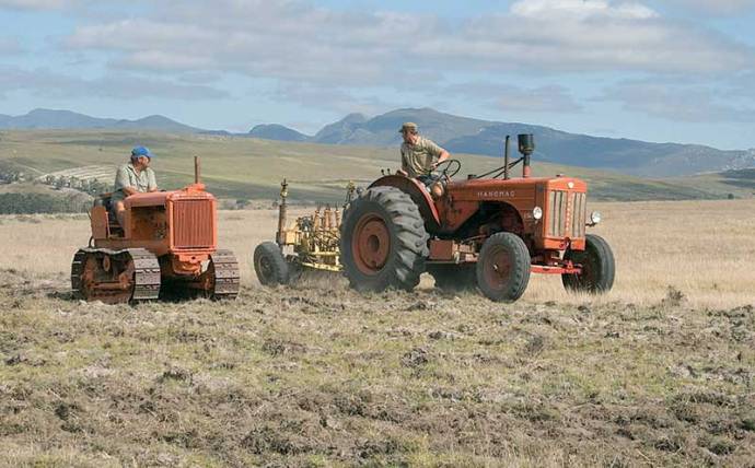Jan on an Allis-Chalmers tractor with caterpillar tracks, while Danie is pulling a veteran disc plough with a Hanomag